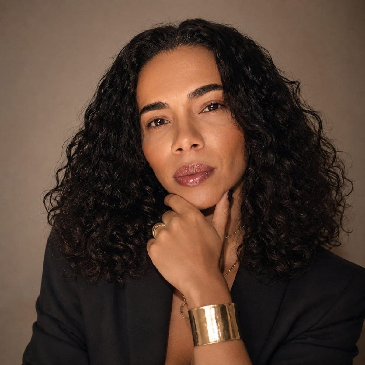 Gabriela Vaz em retrato de estúdio com bracelete dourado